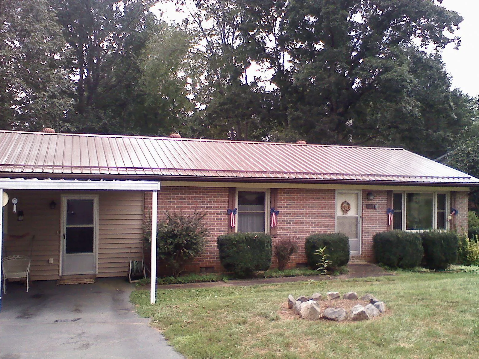 Bronze metal roof and carport on a brick ranch home — Roof Repair work by our crew in Dale